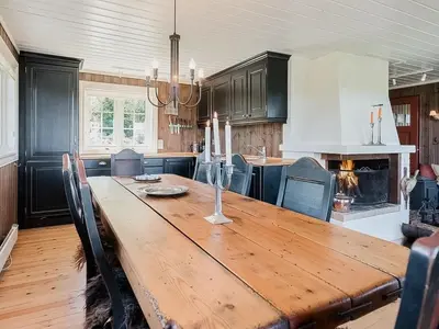a large wooden table in a kitchen with black cabinets at Upgraded Family Cabin At Sangefjell in Ål