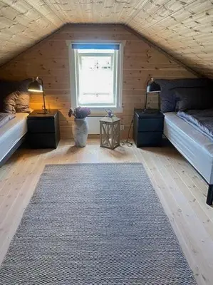 a room with two beds and a dog sitting in front of a window at Family Cabin At Blefjell in Lampeland