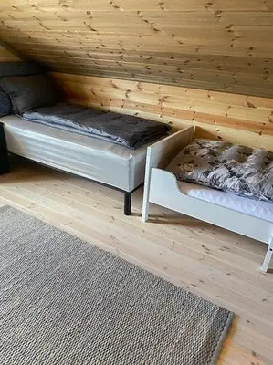 a room with two beds in a wooden cabin at Family Cabin At Blefjell in Lampeland