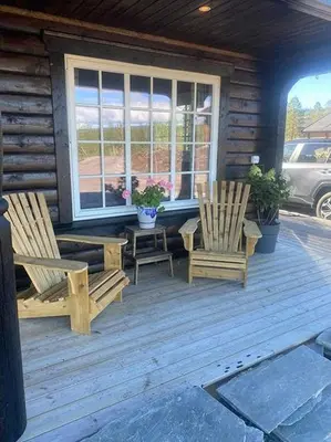 two chairs and a table on the porch of a cabin at Family Cabin At Blefjell in Lampeland