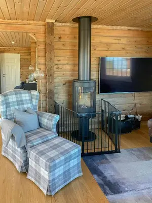 a living room with a fireplace and a couch and a tv at Family Cabin At Blefjell in Lampeland