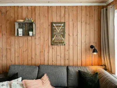 a living room with a couch and a wooden wall at Mountain Gem With Ski Inout In Rauland in Rauland
