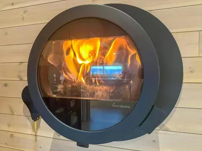 a fire in a fireplace in a wall at Modern Mountain Cabin Near Norefjell in Eggedal