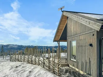 a small building in the snow with a fence at Modern Mountain Cabin Near Norefjell in Eggedal