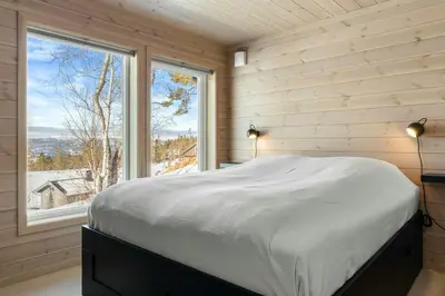 a bed in a room with a large window at Modern Mountain Cabin Near Norefjell in Eggedal