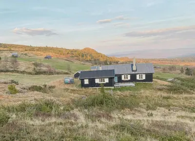 a black house in the middle of a field at Traditional Mountain Cabin Near Hallingskarvet in Torpo