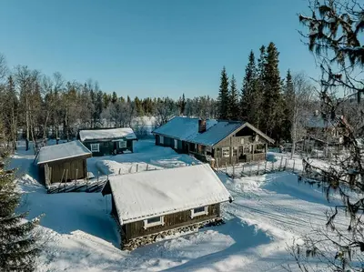 a group of buildings covered in snow with trees at Family Cabin With Shelter By Lake Gautetjern in Gol