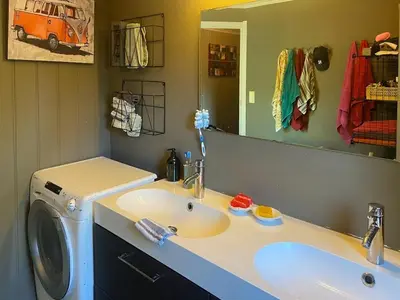 a bathroom with a sink and a washing machine at Sea Cabin With Views On Kallevikevegen in Mosterhamn