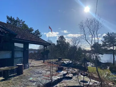 a house with a flag on top of it at Sea Cabin With Views On Kallevikevegen in Mosterhamn