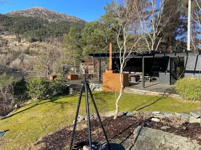 a view of a house with a tree in the yard at Sea Cabin With Views On Kallevikevegen in Mosterhamn