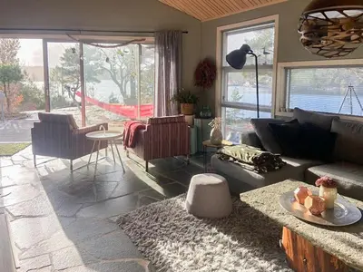 a living room with a couch and a table at Sea Cabin With Views On Kallevikevegen in Mosterhamn