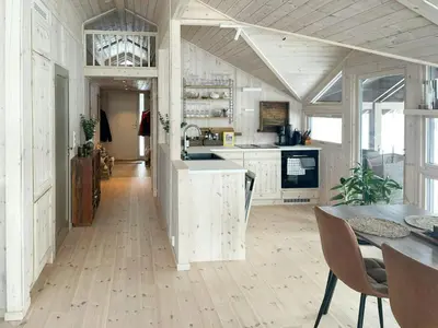 a kitchen with white cabinets and a table with chairs at Cabin With A View And Close To Jotunheimen in Heggenes