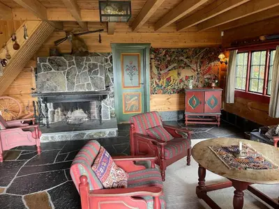 a living room with chairs and a fireplace in a cabin at Traditional Hemsedal family cabin spectacular view in Hemsedal