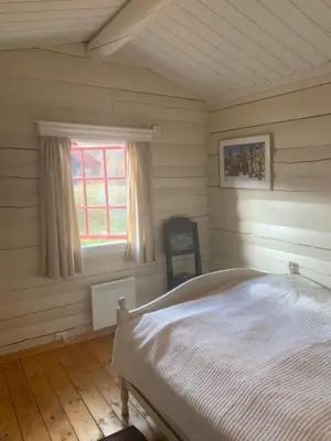 a bedroom with a white bed and a window at Traditional Hemsedal family cabin spectacular view in Hemsedal