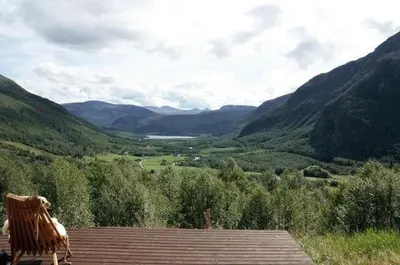 a bench sitting on a deck looking at a valley at Traditional Hemsedal family cabin spectacular view in Hemsedal