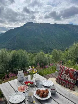 a table with food on it with a view of a mountain at Traditional Hemsedal family cabin spectacular view in Hemsedal