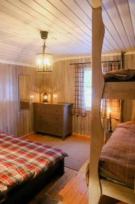 a bedroom with a bed and a dresser in a room at Charming Cabin In Vikerfjell in Hønefoss