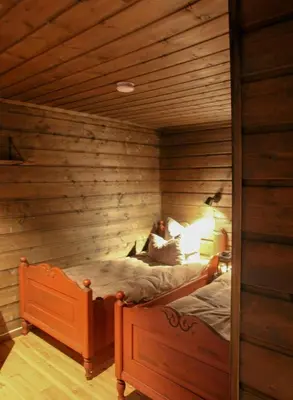 a bedroom with a bed in a wooden room at Charming Cabin In Vikerfjell in Hønefoss