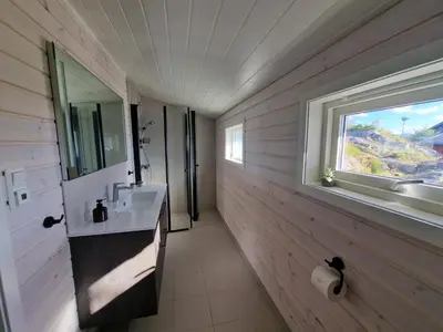 a bathroom with a sink and a window at Færøya 49 in Nekkøyane