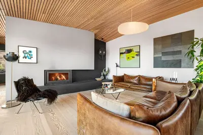 a living room with leather furniture and a fireplace at Stay in The Hollywood Hills of Bergen with Breathtaking Views in Bergen
