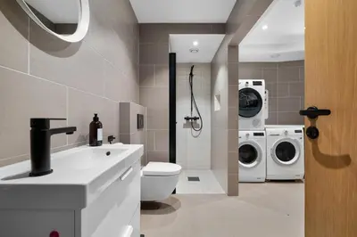 a bathroom with a toilet and a washer and dryer at Stay in The Hollywood Hills of Bergen with Breathtaking Views in Bergen