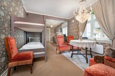 a bedroom with a bed and a table and chairs at Jugend 1904 in Ålesund