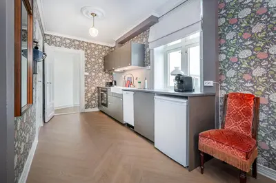 a kitchen with a counter and a red chair at Jugend 1904 in Ålesund