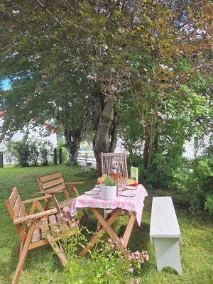 a picnic table and chairs in a yard with a tree at Villa ved sjøen og fjellene in Myklebostad