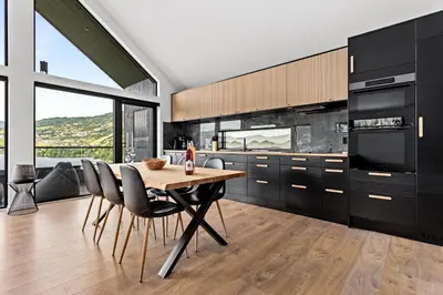 a kitchen with a wooden table and black cabinets at Top-Floor Lakefront Apartment near Ski Resort in Hafslo