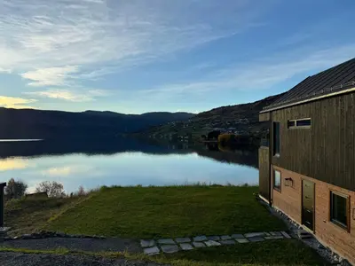 a house with a view of a lake at Top-Floor Lakefront Apartment near Ski Resort in Hafslo