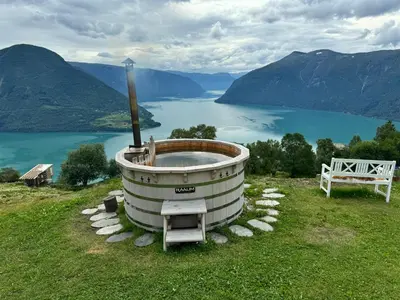 a bath tub in a field with a view of a lake at Top-Floor Lakefront Apartment near Ski Resort in Hafslo