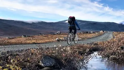 a person riding a bike on a dirt road at Ski in & out hytte på Lemonsjøen i Jotunheimen in Randsverk