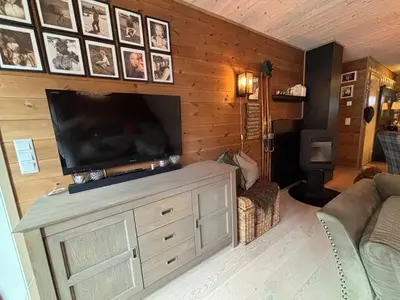 a living room with a flat screen tv on a wooden wall at Apartment in Myrkdalen Voss in Vossevangen