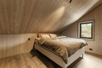 a bed in a room with a wooden ceiling at Hydla Mountain Lodge in Stryn