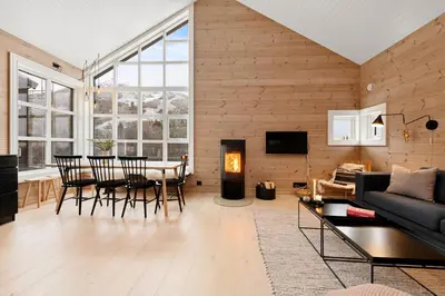 a living room with a couch and a table and chairs at Idyllic Apartment at Strandafjellet in Stranda