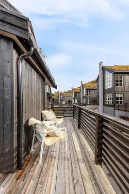 a wooden deck with a chair on top of it at Idyllic Apartment at Strandafjellet in Stranda
