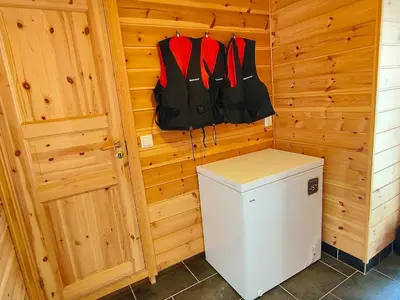 a small refrigerator in a room with wooden walls at cozy house with boat dock, sauna - FJORDTID in Rubbestadneset