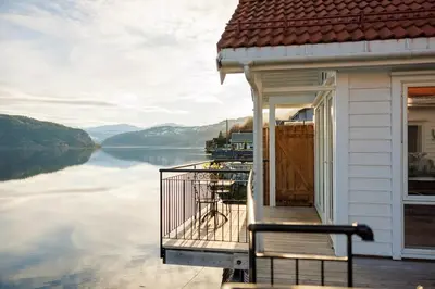 a house with a balcony with a view of a lake at Stryn Fjord Cottage Faleide in Stryn