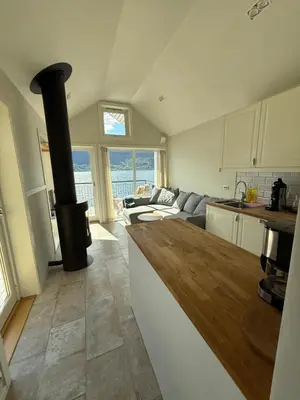 a kitchen and living room with a stove at Stryn Fjord Cottage Faleide in Stryn