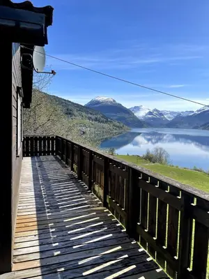 a bridge over a lake with mountains in the background at Stryn - Faleide - Cabin Fjord view in Stryn