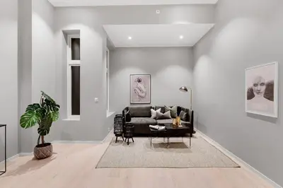 a living room with a black couch and a table at City Centrum Villa Apartments w parking in Bergen