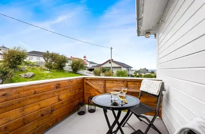 a patio with a table and chairs on a balcony at Nesheim in Alnes