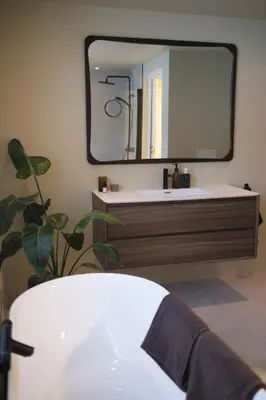 a bathroom with a sink and a large mirror at Nesheim in Alnes
