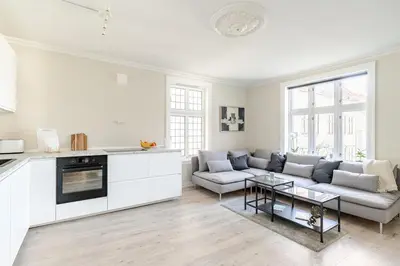 a white living room with a couch and a table at Skuteviken House in Bergen