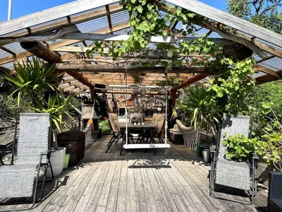 a patio with a table and chairs under a wooden pergola at #Beautiful outdoor area and cozy small cottage# in Fotlandsvåg