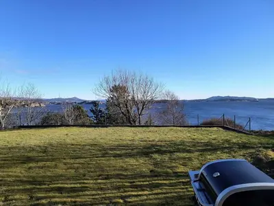 a car parked in a field next to a body of water at Skjærgårdsidyll in Askøy