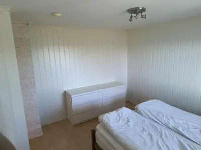 a white room with a bed and a desk at Skjærgårdsidyll in Askøy
