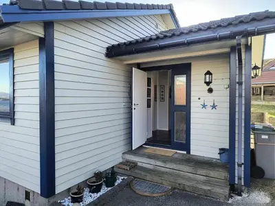 a front door of a house with a wooden porch at Skjærgårdsidyll in Askøy