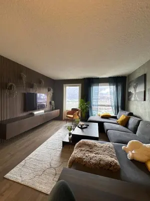 a living room with a blue couch and a tv at 2 Bedroom Apartment with free parking lot in Bergen