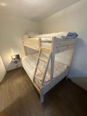 a bunk bed in a small room with a ladder at 2 Bedroom Apartment with free parking lot in Bergen